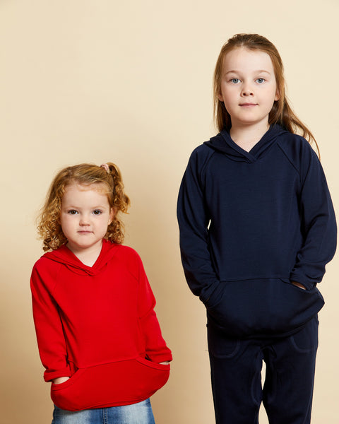 Children wearing soft Australian Merino wool hoodies in red and navy. Designed to wear over other layers as an outer layer. Made in Australia at Woolerina's workrooms at Forbes in central west NSW.