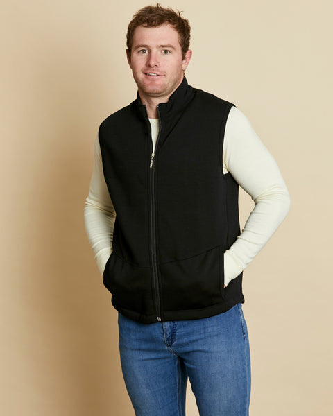 Man wearing a soft Australian Merino wool full zip vest in black. Designed to wear over other layers as an outer layer. Made in Australia at Woolerina's workrooms at Forbes in central west NSW.