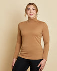 Woman wearing soft Australian Merino wool long sleeve turtleneck in camel. Designed to wear next to the skin as a base layer and also perfect for layering. Made in Australia at Woolerina's workrooms at Forbes in central west NSW.