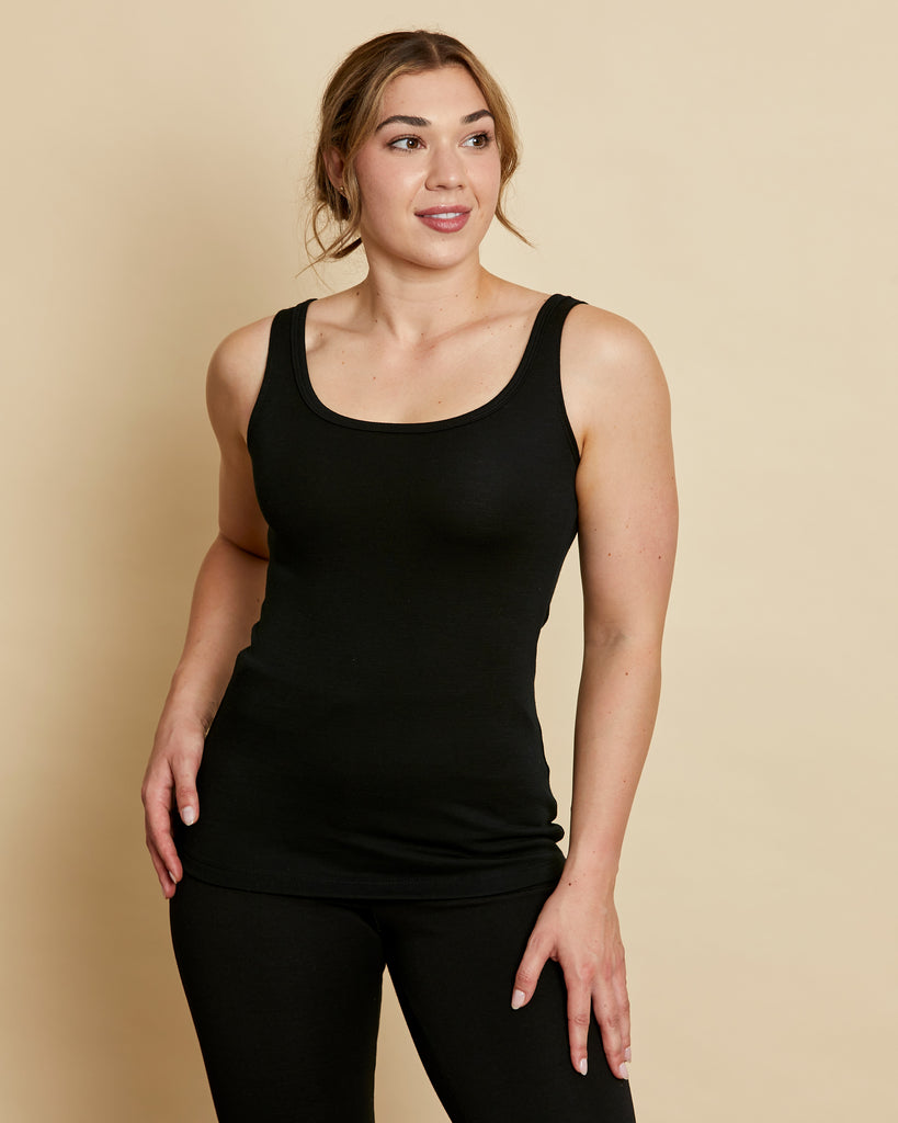 Woman wearing soft Australian Merino wool sleeveless singlet in black. Designed to wear next to the skin as a base layer, it is perfect for layering. Made in Australian at Woolerina's workrooms at Forbes in central west NSW.