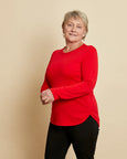 Woman wearing soft Australian Merino wool crew neck pullover in tomato red. Relaxed fitting, designed to wear over other layers as an outer layer or on its own next to the skin. Made in Australia at Woolerina's workrooms at Forbes in central west NSW.