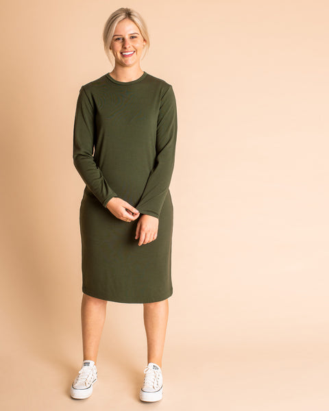 Woman wearing soft Australian Merino wool relaxed fitting long sleeve crew neck dress in hunter green. Designed as a relaxed fit and sitting around knee length. This style is perfect as a base to add other layers. Made in Australia at Woolerina's workrooms at Forbes in central west NSW.