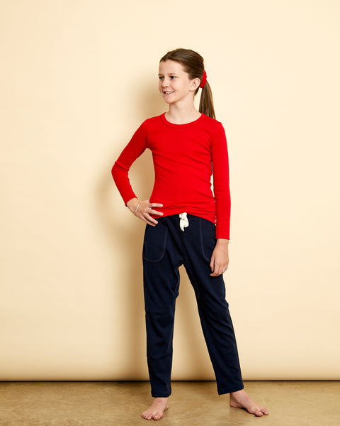 Girl wearing soft Australian Merino wool long sleeve crew neck in red. Designed to wear next to the skin either as a base layer or as a t.shirt style on its own. This style is perfect for layering. Made in Australia at Woolerina's workrooms at Forbes in central west NSW.
