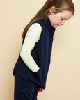 Girl wearing soft Australian Merino wool full zip sleeveless vest in navy. Designed to wear over other layers as an outer layer. Made in Australia at Woolerina's workrooms at Forbes in central west NSW.