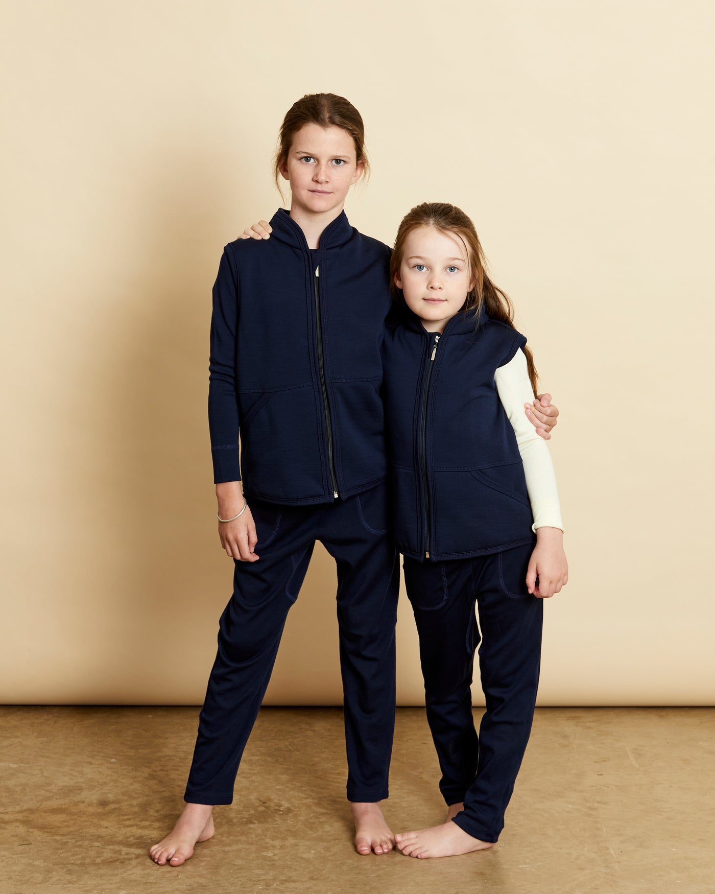 children wearing soft Australian Merino wool full zip sleeveless vest in navy. Designed to wear over other layers as an outer layer. Made in Australia at Woolerina's workrooms at Forbes in central west NSW.