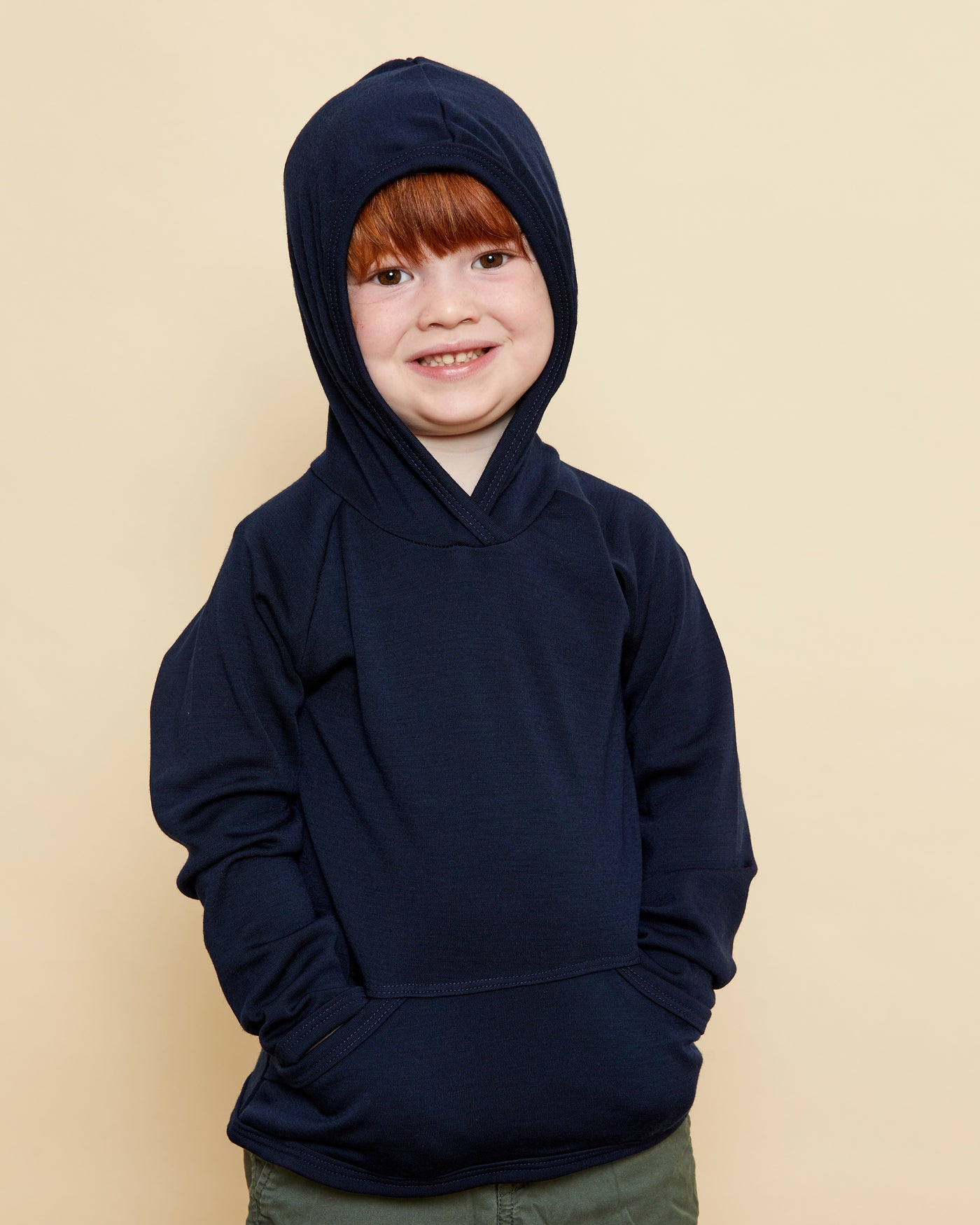 Boy wearing soft Australian Merino wool hoodie in navy. Designed to wear over other layers as an outer layer. Made in Australia at Woolerina's workrooms at Forbes in central west NSW.