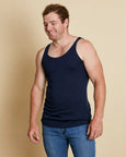 Man wearing soft Australia Merino wool sleeveless singlet in navy. Designed to wear next to the skin as a base layer/thermal style, under other layers. Made in Australia at Woolerina's workrooms at Forbes in central west NSW.