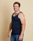 Man wearing soft Australia Merino wool sleeveless singlet in navy. Designed to wear next to the skin as a base layer/thermal style, under other layers. Made in Australia at Woolerina's workrooms at Forbes in central west NSW.