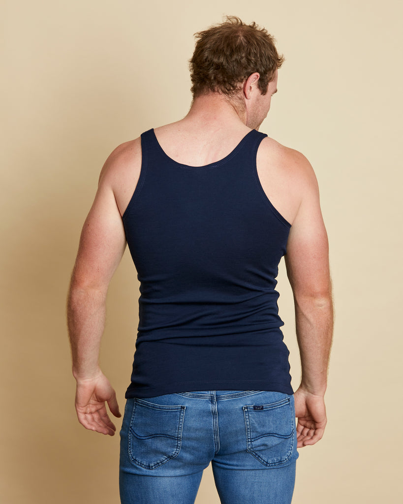 Man wearing soft Australia Merino wool sleeveless singlet in navy. Designed to wear next to the skin as a base layer/thermal style, under other layers. Made in Australia at Woolerina's workrooms at Forbes in central west NSW.