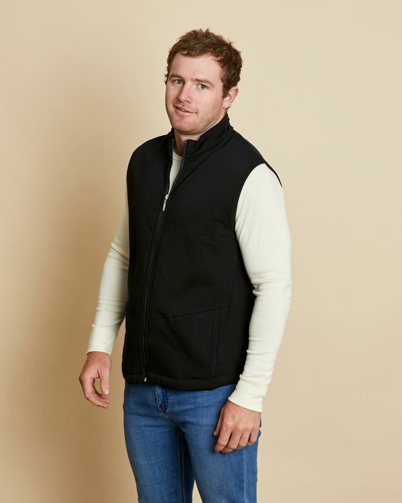 Man wearing a soft Australian Merino wool full zip vest in black. Designed to wear over other layers as an outer layer. Made in Australia at Woolerina's workrooms at Forbes in central west NSW.