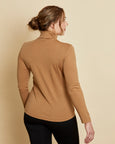 Woman wearing soft Australian Merino wool long sleeve turtleneck in camel. Designed to wear next to the skin as a base layer and also perfect for layering. Made in Australia at Woolerina's workrooms at Forbes in central west NSW.