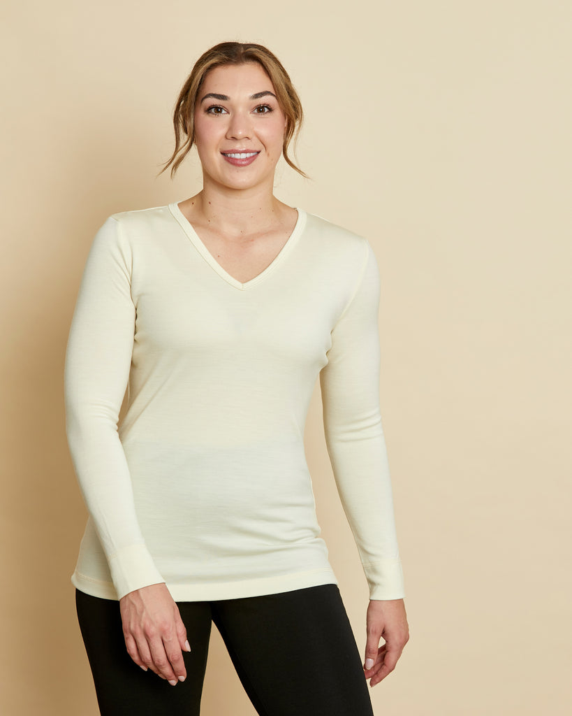 Woman wearing soft Australian Merino wool long sleeve V neck in natural. Designed to wear next to the skin either as a base layer or as a t.shirt style on its own. This style is perfect for layering. Made in Australia at Woolerina's workrooms at Forbes in central west NSW.