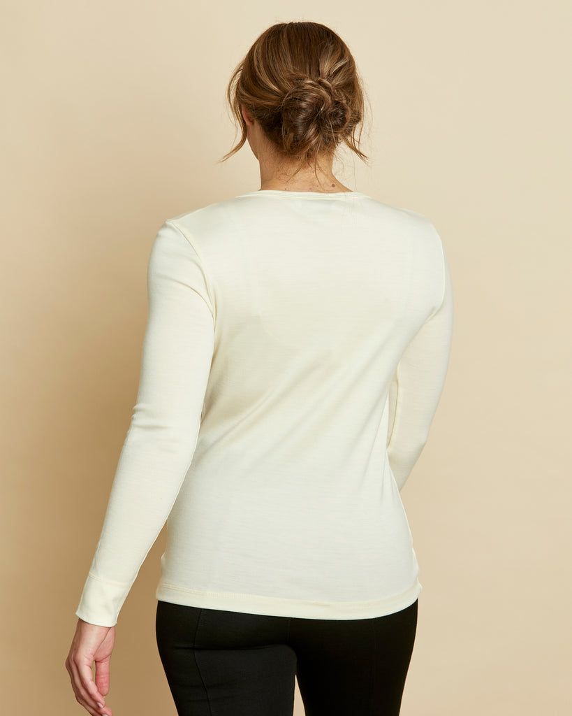 Woman wearing soft Australian Merino wool long sleeve V neck in natural. Designed to wear next to the skin either as a base layer or as a t.shirt style on its own. This style is perfect for layering. Made in Australia at Woolerina's workrooms at Forbes in central west NSW.
