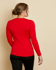 Woman wearing soft Australian Merino wool long sleeve crew neck in tomato red. Designed to wear next to the skin either as a base layer or as a t.shirt style on its own. This style is perfect for layering. Made in Australia at Woolerina's workrooms at Forbes in central west NSW.