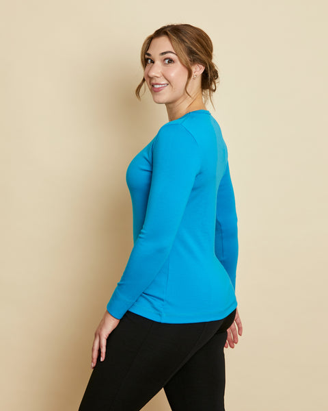 Woman wearing soft Australian Merino wool long sleeve crew neck in turquoise. Designed to wear next to the skin either as a base layer or as a t.shirt style on its own. This style is perfect for layering. Made in Australia at Woolerina's workrooms at Forbes in central west NSW.