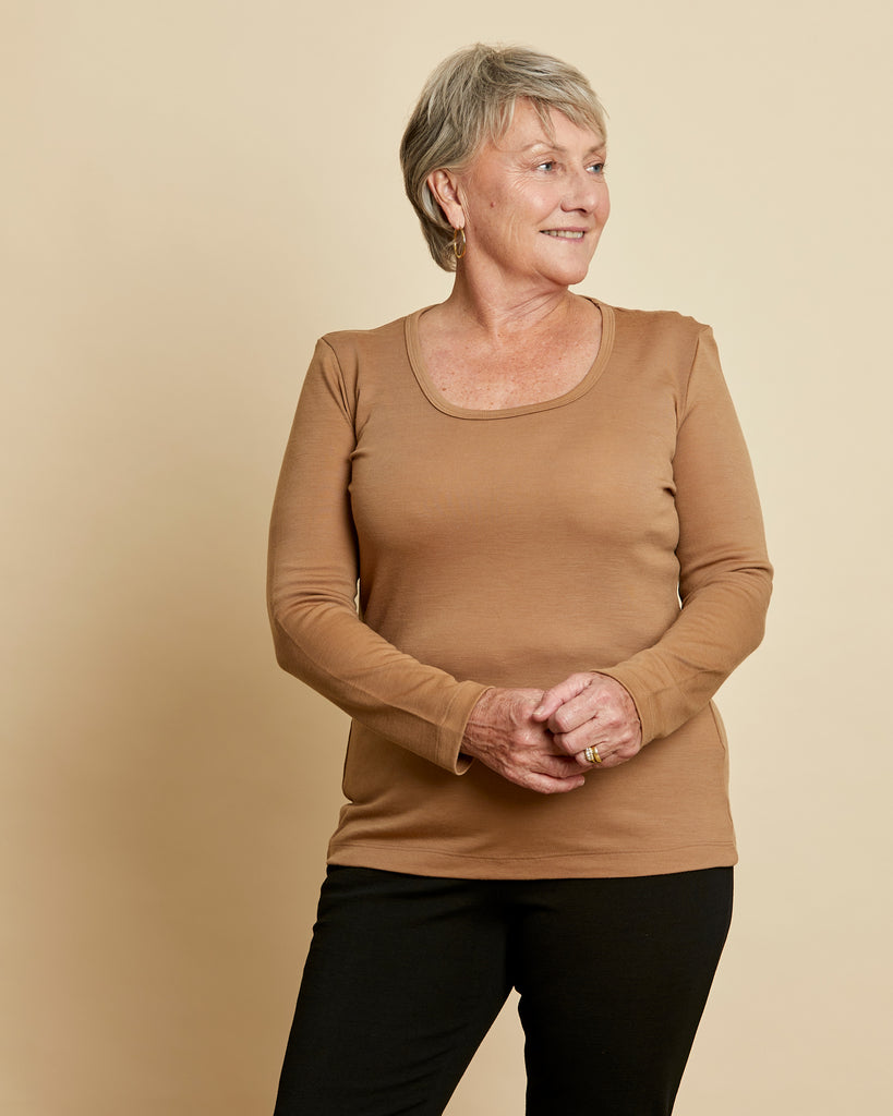 Woman wearing soft Australian Merino wool long sleeve scoop neck in camel. Designed to wear next to the skin as a base layer or on its own as a t.shirt style, it is perfect for layering! Made in Australia at Woolerina workrooms at Forbes in central west NSW.