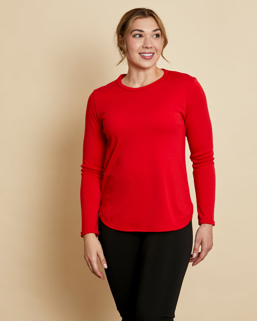 Woman wearing soft Australian Merino wool crew neck pullover in tomato red. Relaxed fitting, designed to wear over other layers as an outer layer or on its own next to the skin. Made in Australia at Woolerina's workrooms at Forbes in central west NSW.