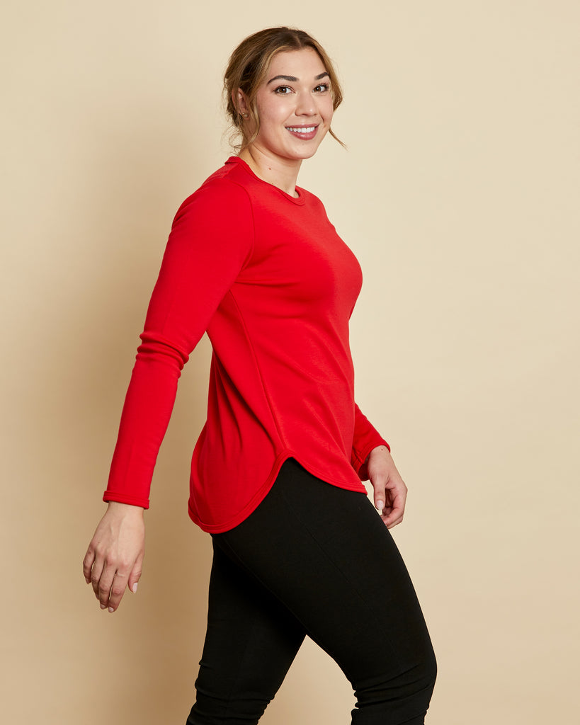 Woman wearing soft Australian Merino wool crew neck pullover in tomato red. Relaxed fitting, designed to wear over other layers as an outer layer or on its own next to the skin. Made in Australia at Woolerina's workrooms at Forbes in central west NSW.