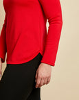 Woman wearing soft Australian Merino wool crew neck pullover in tomato red. Relaxed fitting, designed to wear over other layers as an outer layer or on its own next to the skin. Made in Australia at Woolerina's workrooms at Forbes in central west NSW.