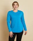 Woman wearing soft Australian Merino wool crew neck pullover in turquoise. Relaxed fitting, designed to wear over other layers as an outer layer or on its own next to the skin. Made in Australia at Woolerina's workrooms at Forbes in central west NSW.