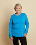 Woman wearing soft Australian Merino wool crew neck pullover in turquoise. Relaxed fitting, designed to wear over other layers as an outer layer or on its own next to the skin. Made in Australia at Woolerina's workrooms at Forbes in central west NSW.