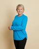 Woman wearing soft Australian Merino wool crew neck pullover in turquoise. Relaxed fitting, designed to wear over other layers as an outer layer or on its own next to the skin. Made in Australia at Woolerina's workrooms at Forbes in central west NSW.