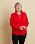 Woman wearing a soft Australian Merino wool pullover with a quarter zip in tomato red. Relaxed fitting, designed to wear over other layers as an outer layer or on its own next to the skin. Made in Australia at Woolerina's workroom at Forbes in central west NSW.