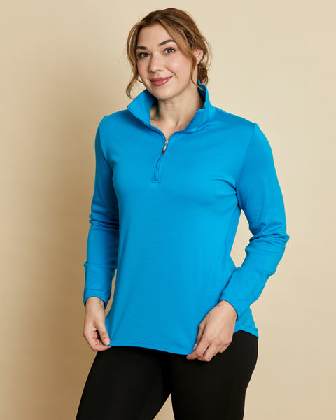 Woman wearing a soft Australian Merino wool pullover with a quarter zip in turquoise. Relaxed fitting, designed to wear over other layers as an outer layer or on its own next to the skin. Made in Australia at Woolerina's workroom at Forbes in central west NSW.
