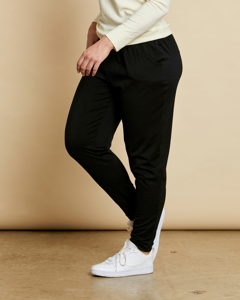 Woman wearing soft Australian Merino wool lightweight, relaxed fitting "happy pant" in black. relaxed fitting around the hips, tapering in at the ankle and with pockets and an elastic waist. Made in Australia at Woolerina's workrooms at Forbes in central west NSW.