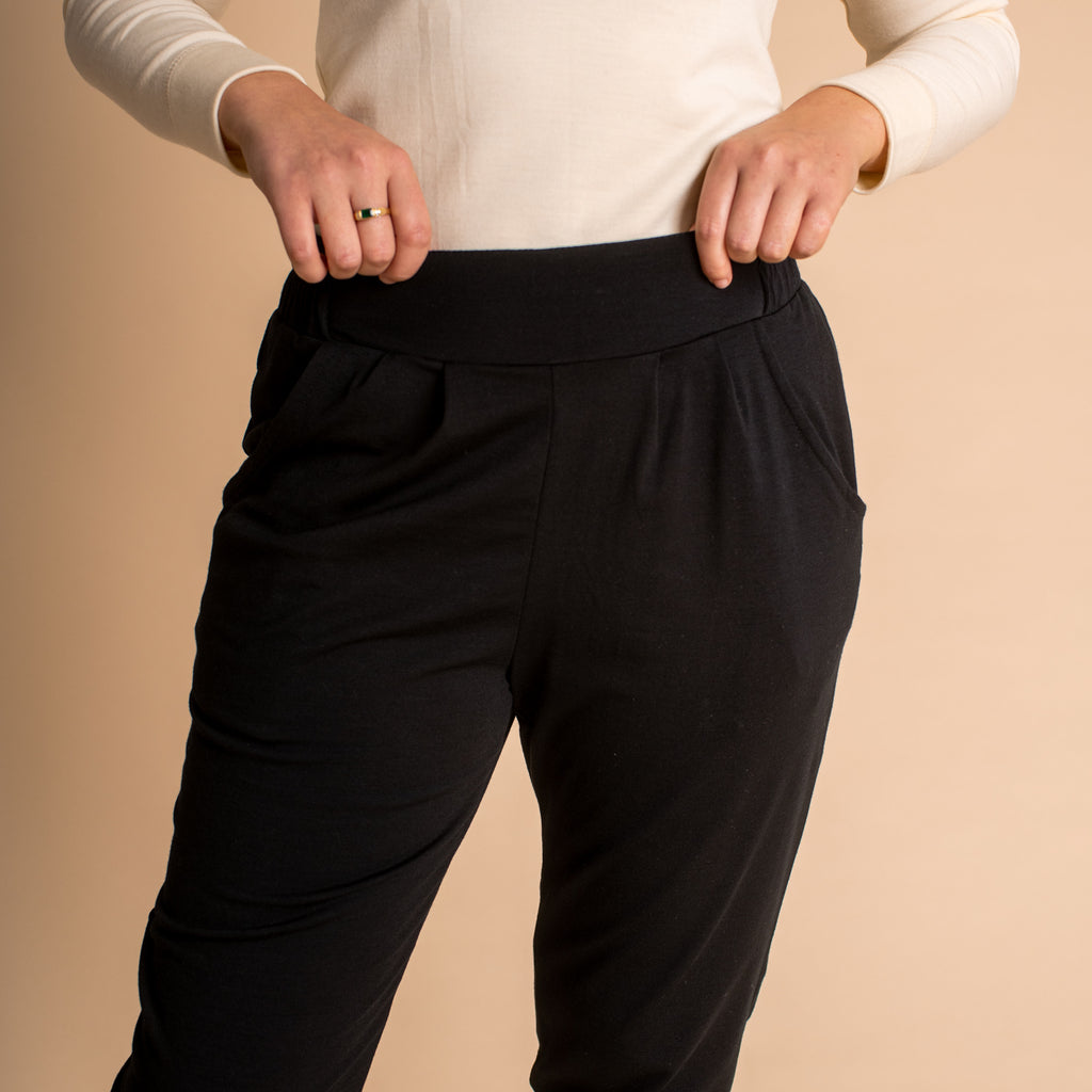 Woman wearing soft Australian Merino wool lightweight, relaxed fitting "happy pant" in black. relaxed fitting around the hips, tapering in at the ankle and with pockets and an elastic waist. Made in Australia at Woolerina's workrooms at Forbes in central west NSW.